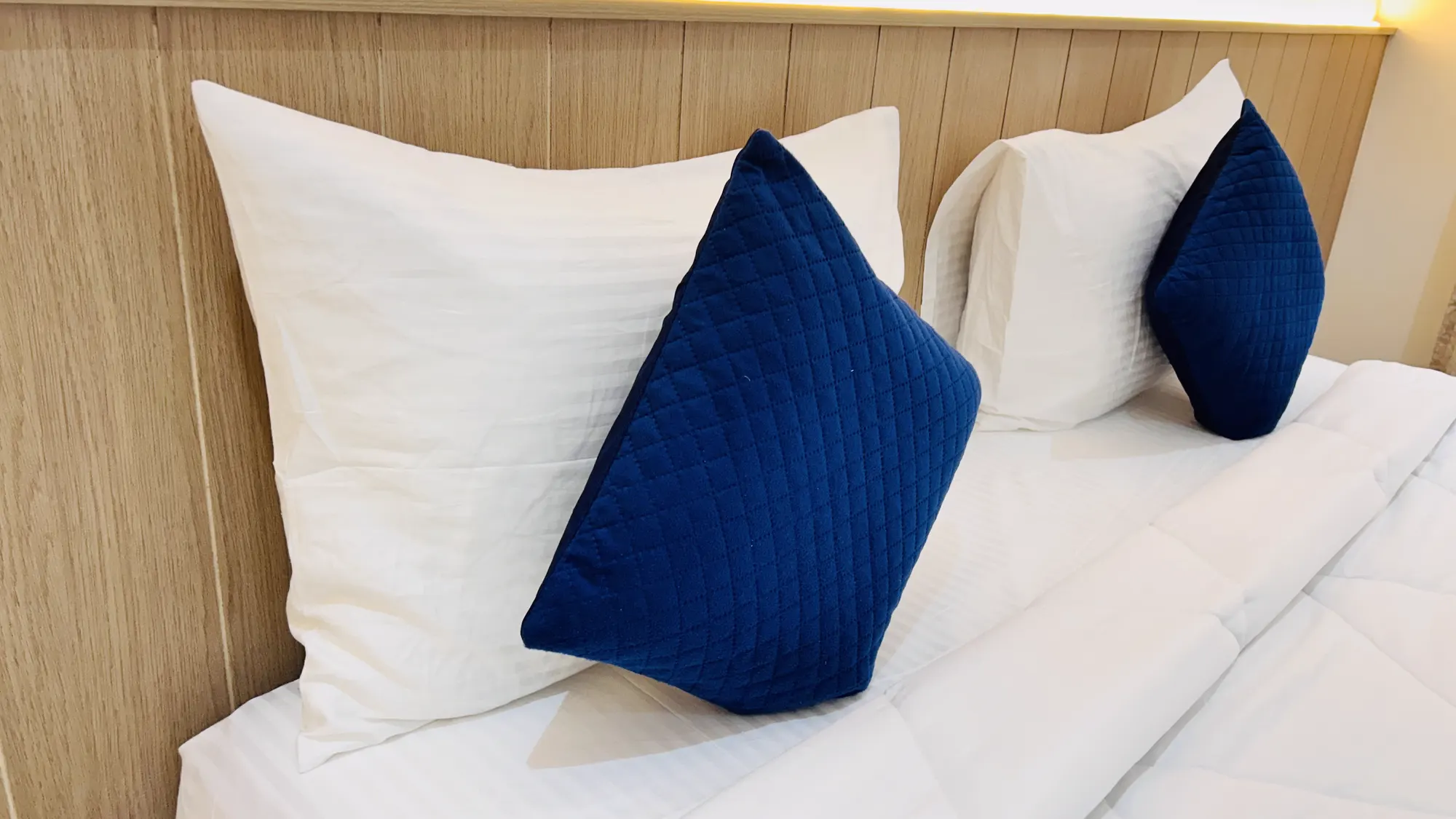 Navy cushions and fresh linen in a Jay Mahal guest room