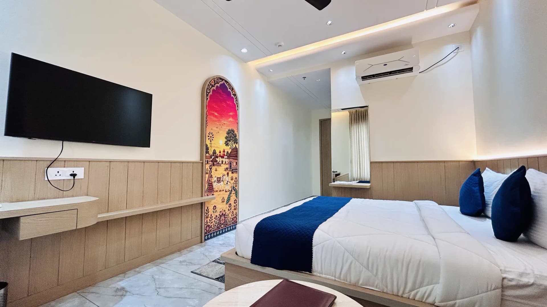 Room with a painted arch mural and plush bed at Jay Mahal