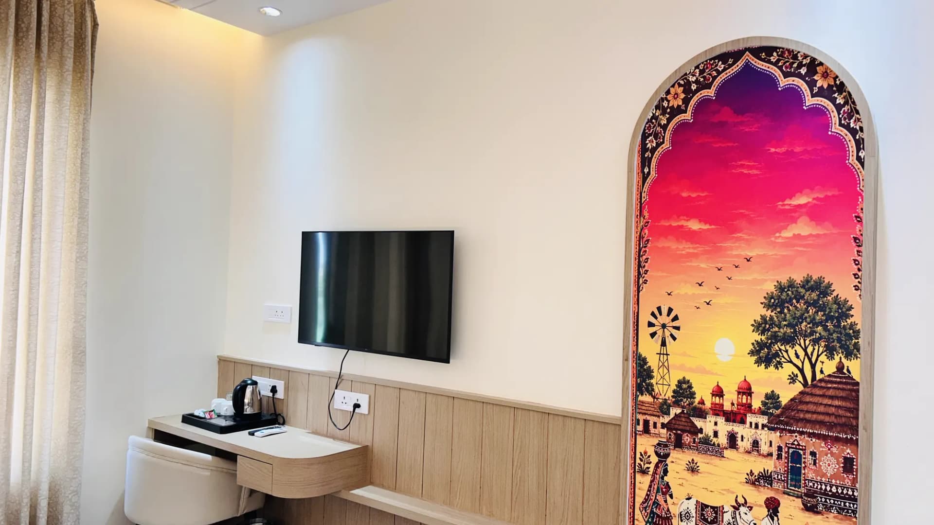 Guest room with a sunset mural and TV unit at Jay Mahal