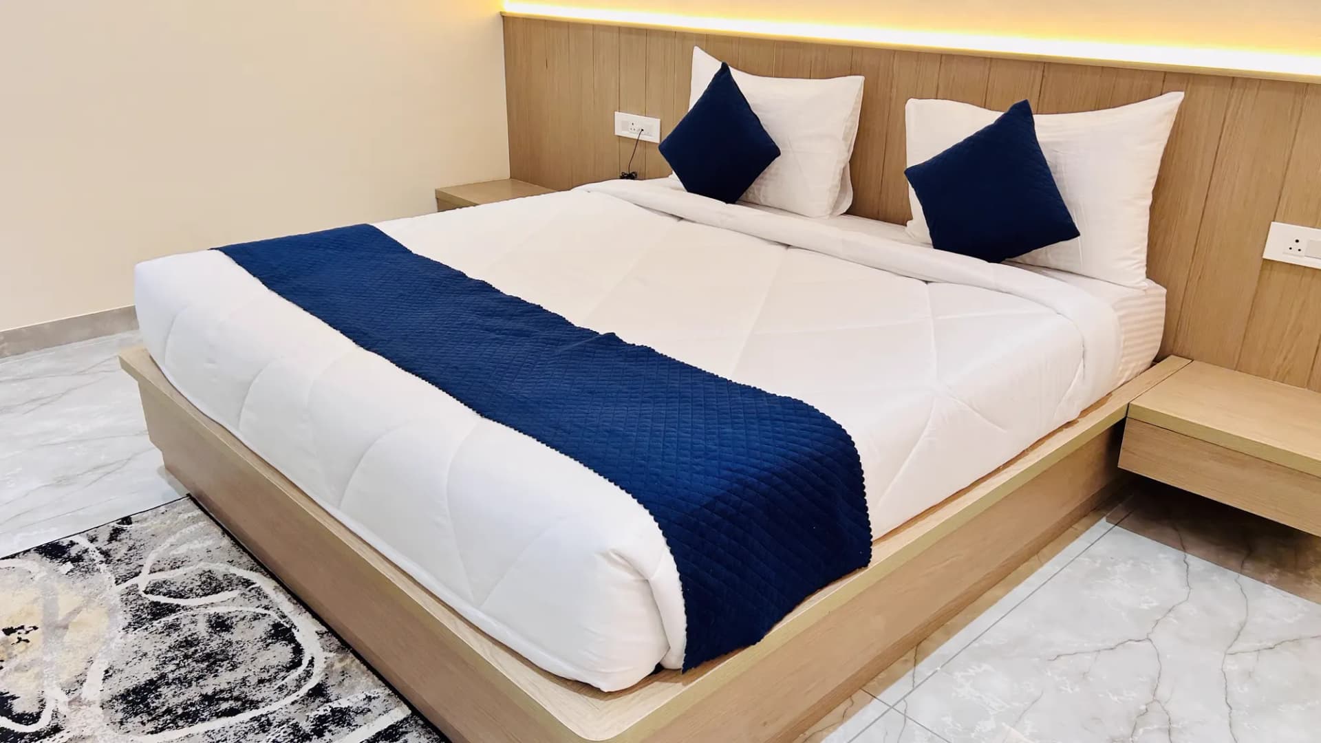 Soft pillows and warm headboard lighting in a Jay Mahal room